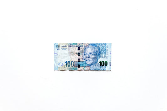 100 mexican peso bill on black textile
