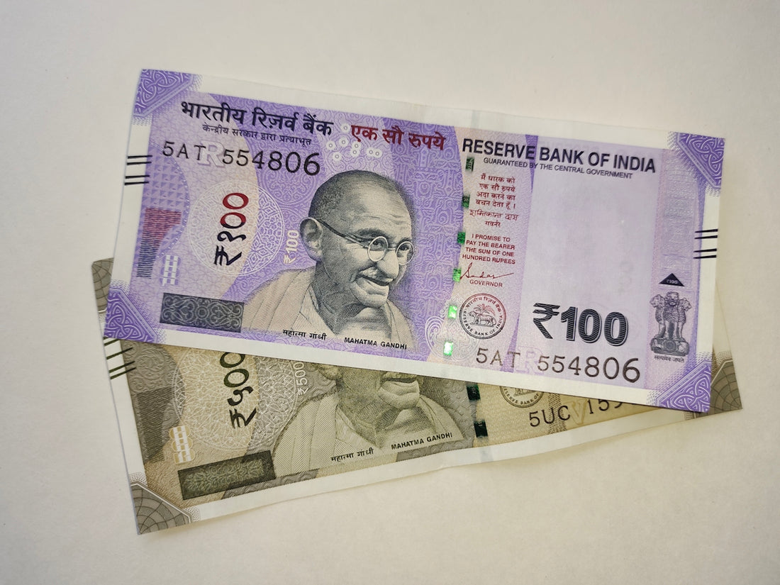 two indian currency bills laying on top of each other