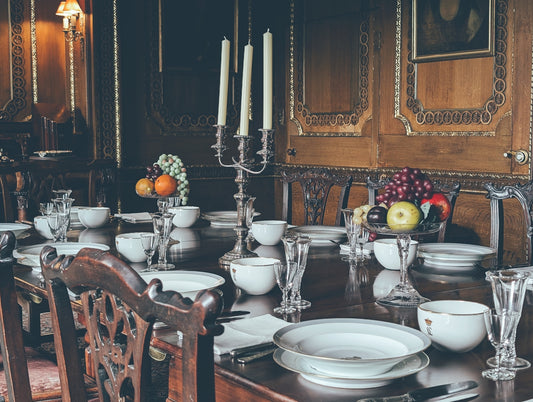 A dining room table set with white plates and silverware