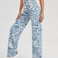 High-Waist Denim Pants with Blue Swirl Print – Stylish Wavy Ripple Graphic, Zipper Button Closure, and Slash Pockets - Ladies