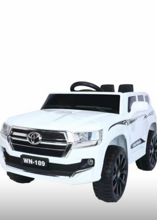 A white Toyota Cruiser Ride On Car designed for kids, featuring a 12v rechargeable battery, music player, and LED lights with opening doors.